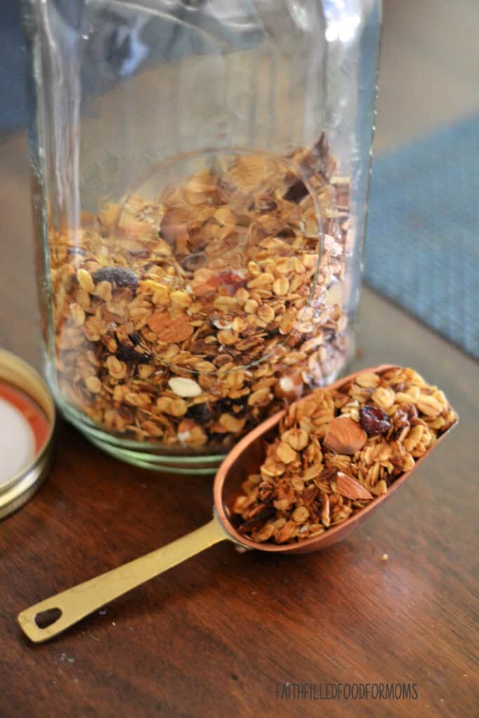Easy Homemade Simple Granola Recipe granola in a mason jar with scoop of granola beside it.