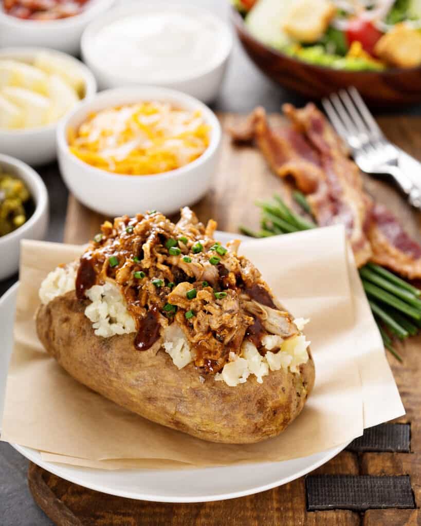 ideas for baked potato toppings Baked Potato with pulled pork and BBQ sauce on top. Also a few cut chives.