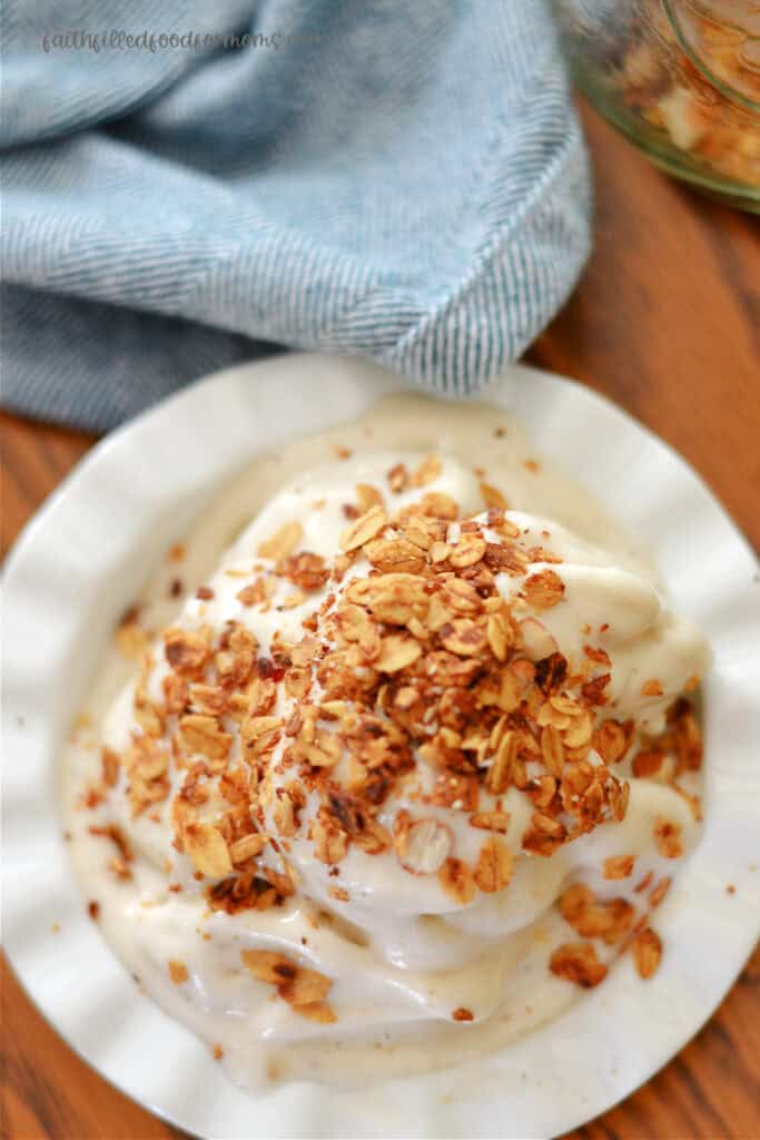 Banana Ice Cream in a white bowl with granola sprinkled over it.