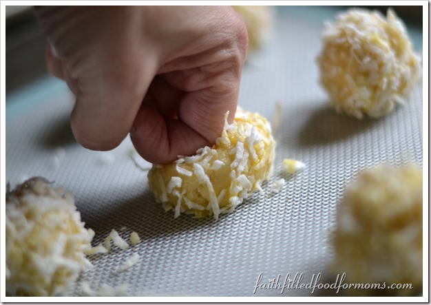 Coconut Lemon Thumbprint Meringue Cookie Recipe pressing thumb into cookie balls to make a well for lemon filling