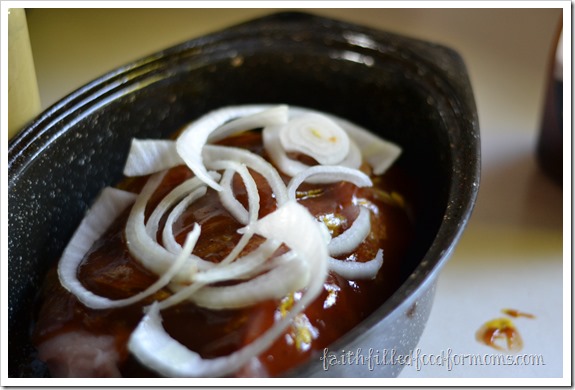 Easy Roasted Pork Sandwich Easy Roasted Pork Sandwich topped with onions in roasting pan.