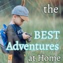 Boy looking at his camera in a field adventure