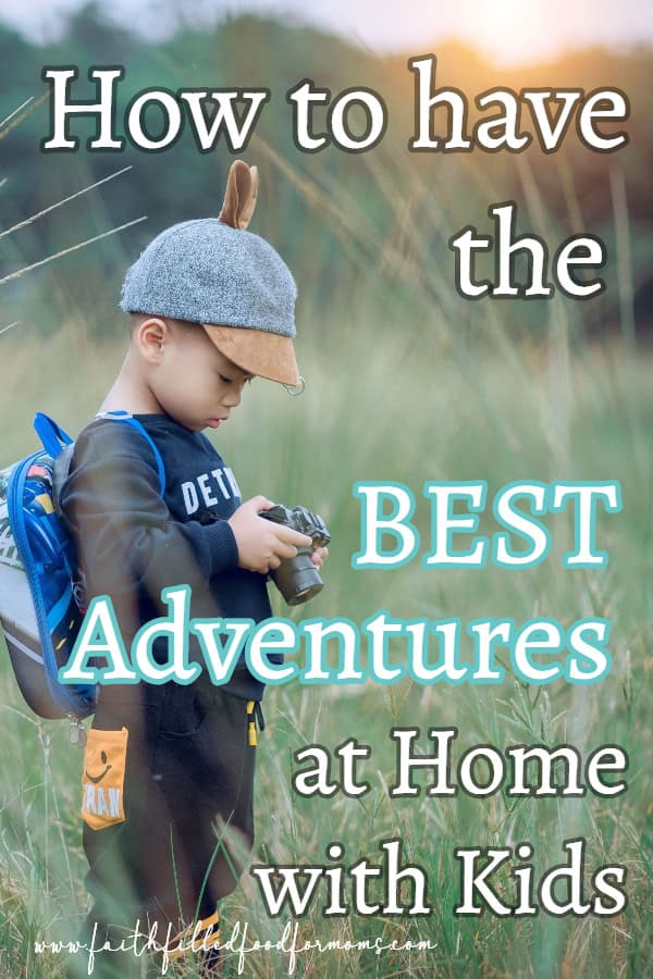 Boy looking at his camera in a field adventure