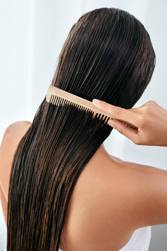 Woman brushing her long wet dark brown hair