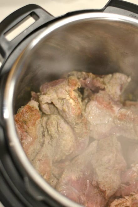 Pork Carnitas meat being browned in the instant pot / crockpot