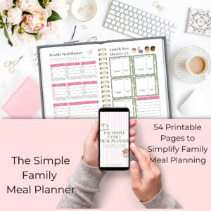 Simple Family Meal Planning System on desktop layout with hands holding phone of planner cover.