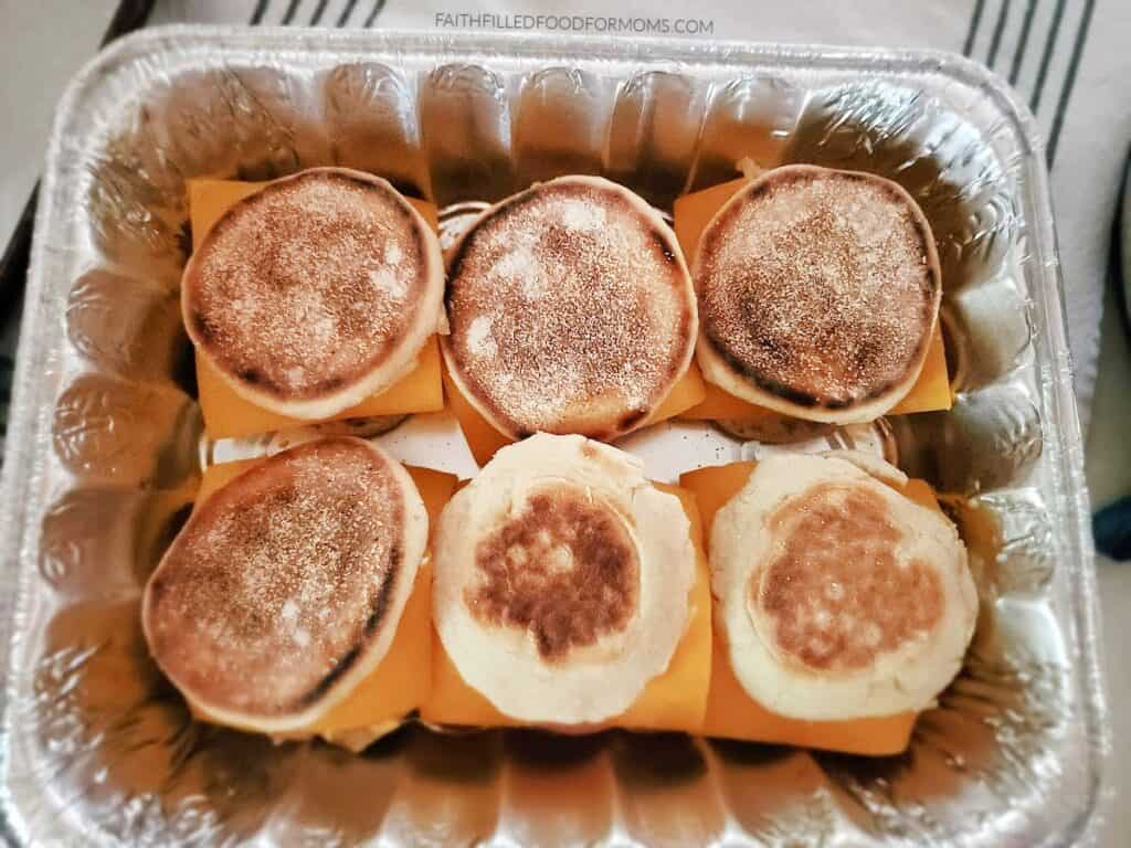 make-ahead breakfast sandwiches first row of breakfast sandwiches for a crowd in a foil pan