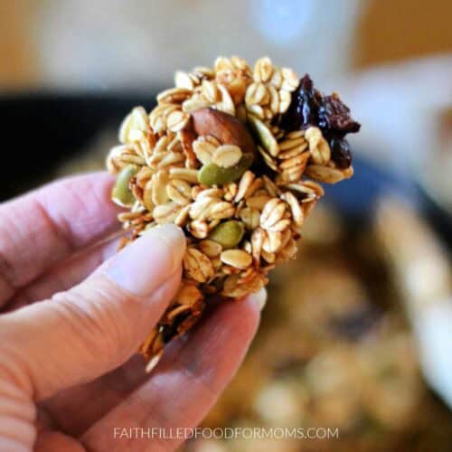 holding a chunk of the chunky stovetop granola in hand