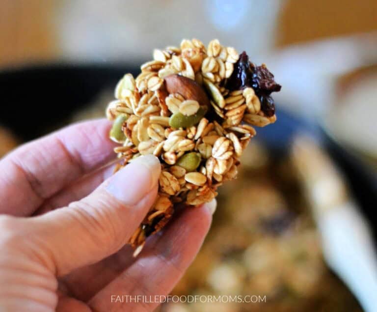 holding a chunk of the chunky stovetop granola in hand