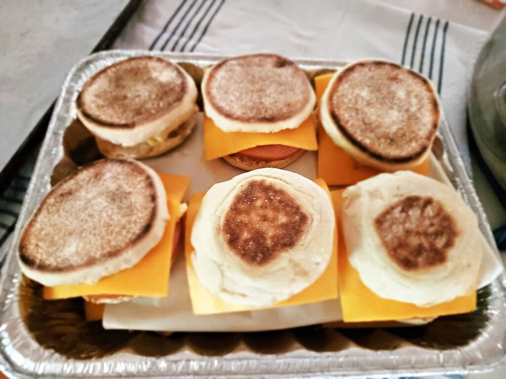 Canadian bacon breakfast sandwiches second row of English muffin breakfast sandwiches in foil pan