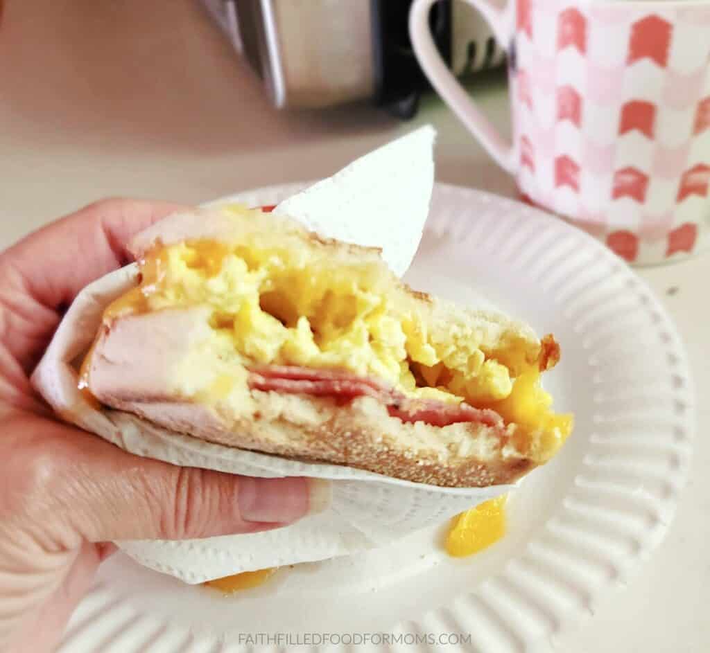 breakfast sandwiches for a crowd Canadian bacon breakfast sandwich with a bite out of it.