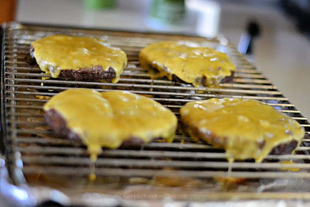 Frozen hamburgers with melted cheese Oven-baked frozen hamburgers topped with melted cheese after broiling.