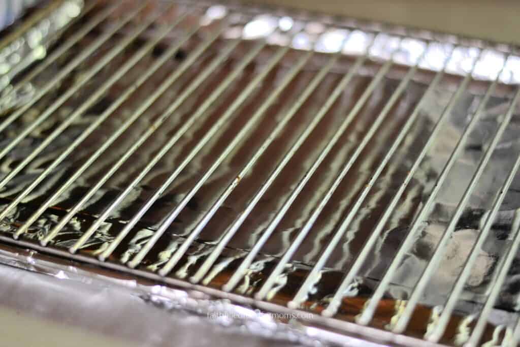 Wire rack for oven-baked frozen hamburgers Wire rack placed over a foil-lined baking sheet for cooking frozen hamburger patties in the oven.